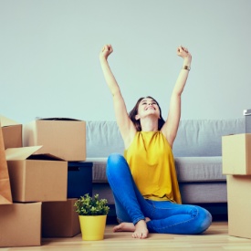 Mujer junto a las cajas de una mudanza